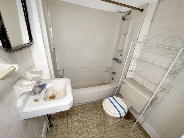 full bath featuring a sink, tile walls, bathtub / shower combination, and toilet