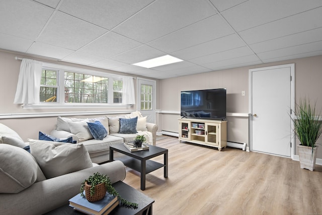 living area featuring light wood-style flooring, a paneled ceiling, a baseboard heating unit, and a baseboard radiator