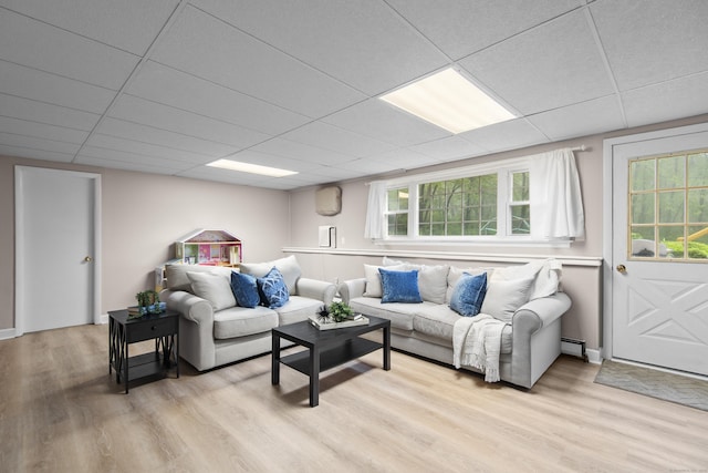 living area with light wood-style floors and a drop ceiling