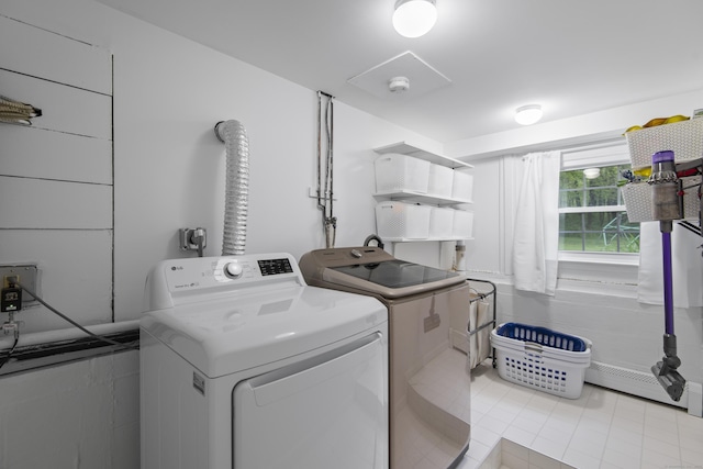 clothes washing area with washing machine and dryer and light tile patterned floors