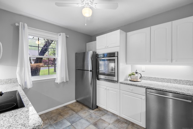 kitchen featuring stainless steel appliances, white cabinets, ceiling fan, baseboards, and light stone counters
