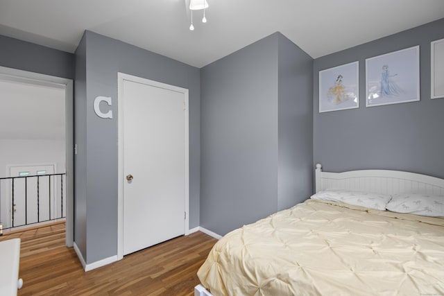 bedroom with wood finished floors and baseboards