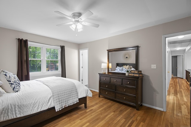 bedroom featuring wood finished floors, baseboards, and a ceiling fan