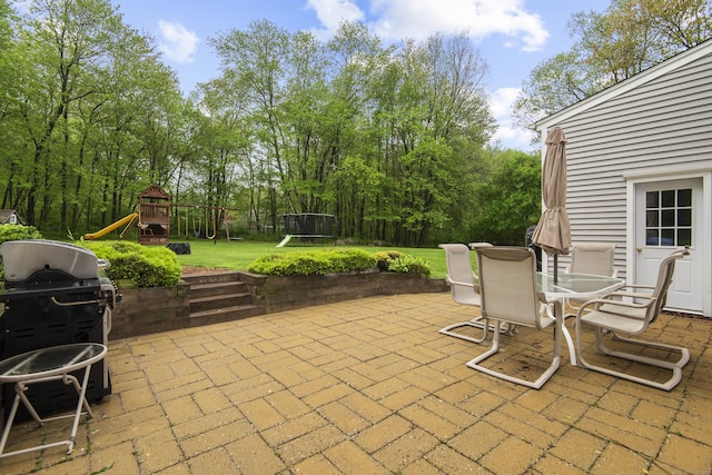 view of patio / terrace featuring a playground, outdoor dining area, and a grill