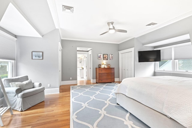 bedroom featuring baseboards, multiple windows, light wood-style floors, and visible vents
