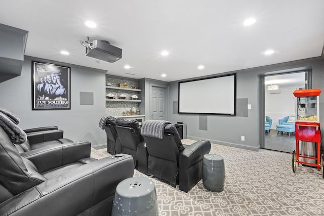 carpeted home theater room with a bar, baseboards, built in shelves, ornamental molding, and recessed lighting