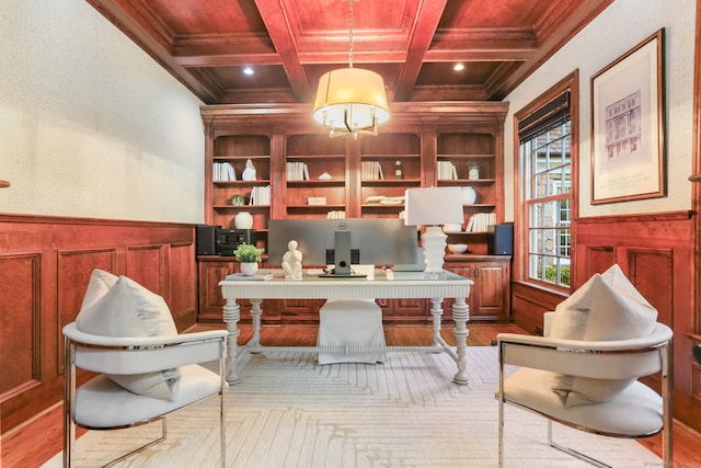 office area featuring coffered ceiling, built in features, wood finished floors, and ornamental molding