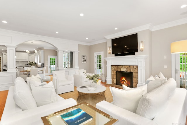 living room with arched walkways, ornamental molding, recessed lighting, and decorative columns