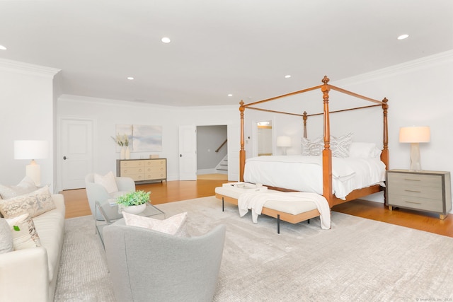 bedroom featuring wood finished floors, ornamental molding, and recessed lighting