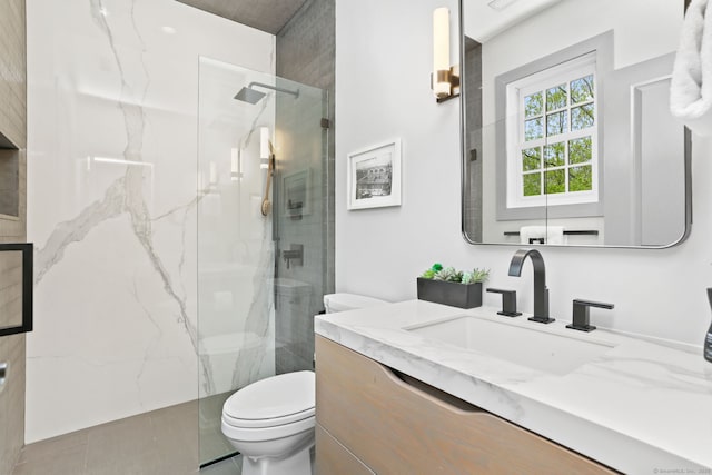 bathroom with toilet, vanity, and a marble finish shower