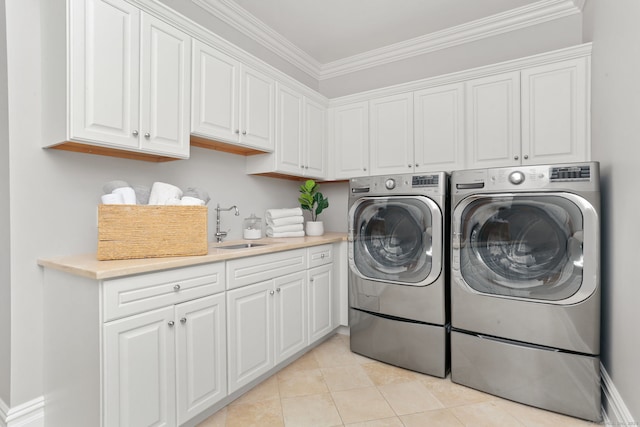 laundry room with light tile patterned floors, ornamental molding, a sink, washer and clothes dryer, and cabinet space