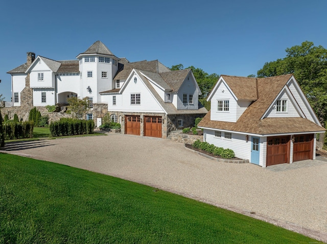 25 Tokeneke Trl, Darien, CT 06820 - shingle-style home featuring stone siding, driveway, an attached garage, and a front lawn