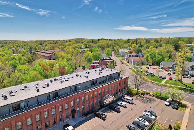drone / aerial view featuring a wooded view