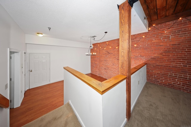 hall with carpet flooring and brick wall