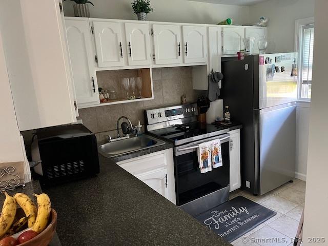 57 Meetinghouse Vlg Unit 6, Meriden, CT 06450 - kitchen featuring white cabinets, stainless steel appliances, dark countertops, and a sink