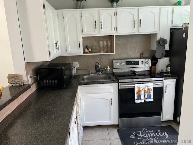 57 Meetinghouse Vlg Unit 6, Meriden, CT 06450 - kitchen with black microwave, dark countertops, a sink, stainless steel electric stove, and white cabinetry