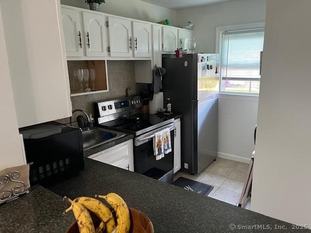 57 Meetinghouse Vlg Unit 6, Meriden, CT 06450 - kitchen with stainless steel electric range oven, white cabinets, dark countertops, black microwave, and a sink