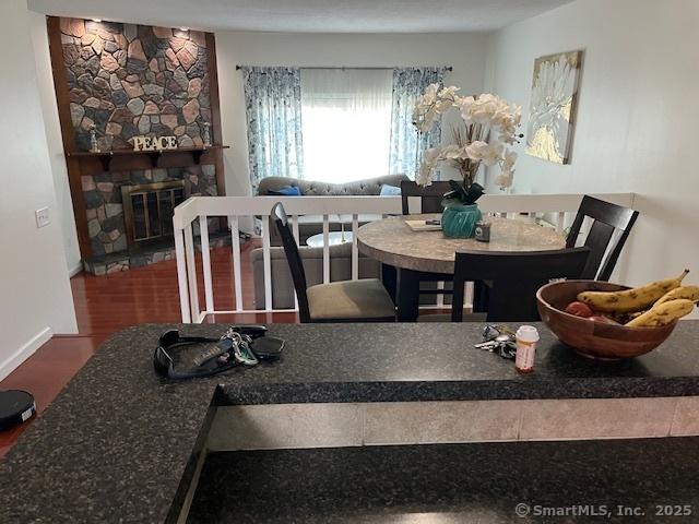 57 Meetinghouse Vlg Unit 6, Meriden, CT 06450 - dining room featuring a stone fireplace and wood finished floors