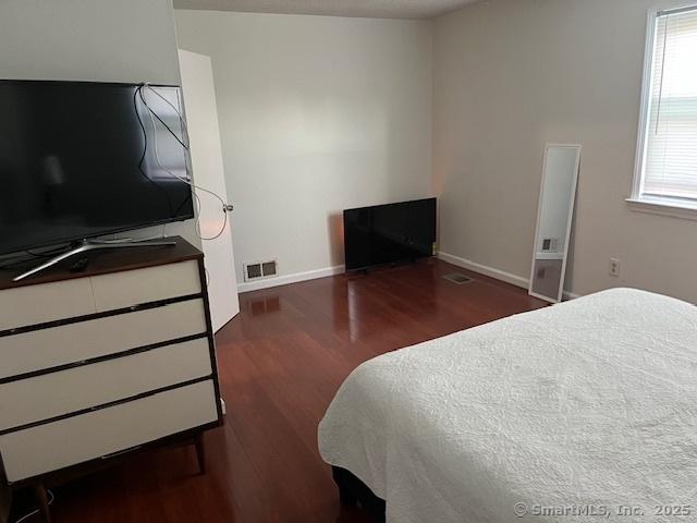 57 Meetinghouse Vlg Unit 6, Meriden, CT 06450 - bedroom with baseboards, wood finished floors, and visible vents