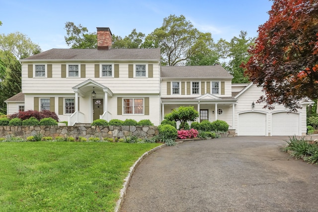 6 Weathervane Hl, Westport, CT 06880 - view of front facade featuring asphalt driveway, a chimney, a front lawn, and an attached garage