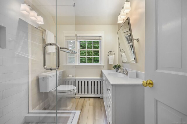 6 Weathervane Hl, Westport, CT 06880 - bathroom featuring vanity, radiator heating unit, wood finished floors, toilet, and a shower stall