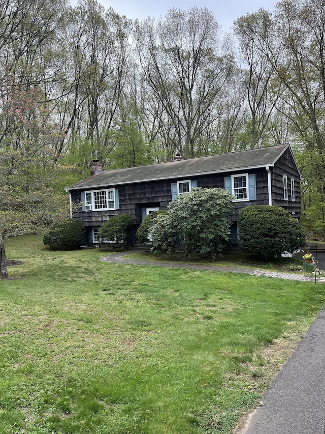 view of front of house with a chimney and a front yard