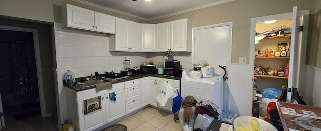 324 Mountain Grove St, Bridgeport, CT 06605 - kitchen with white cabinets, a sink, washer / clothes dryer, light tile patterned floors, and ornamental molding