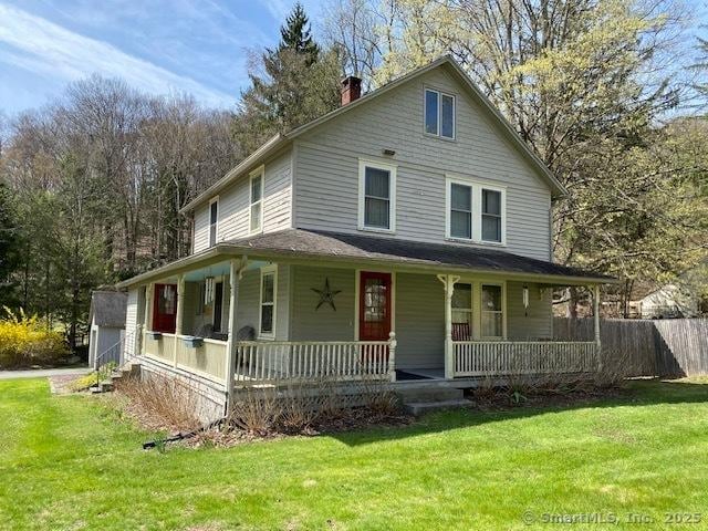 country-style home with a front lawn, covered porch, and a chimney