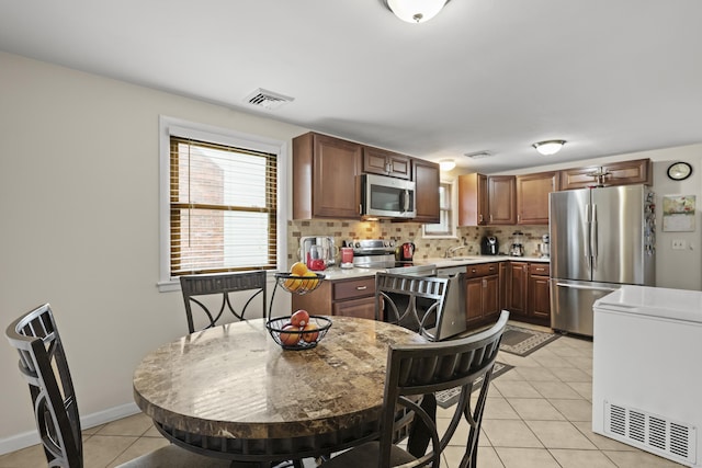 201 Orchard Ave, Newington, CT 06111 - kitchen featuring stainless steel appliances, light tile patterned floors, light countertops, and healthy amount of natural light
