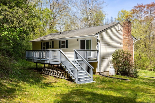 back of property featuring stairs, a wooden deck, a chimney, and a yard