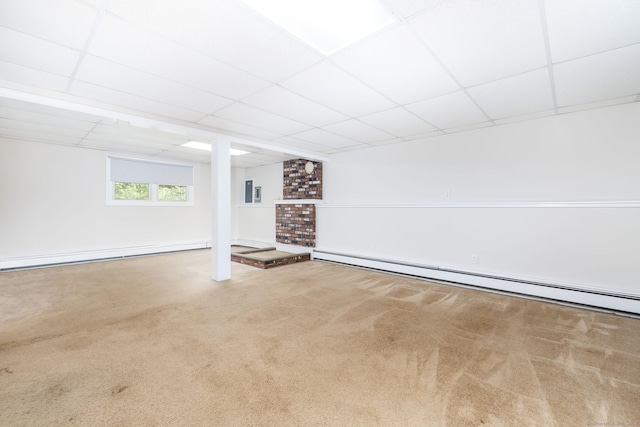 below grade area with a baseboard radiator, carpet, and a paneled ceiling