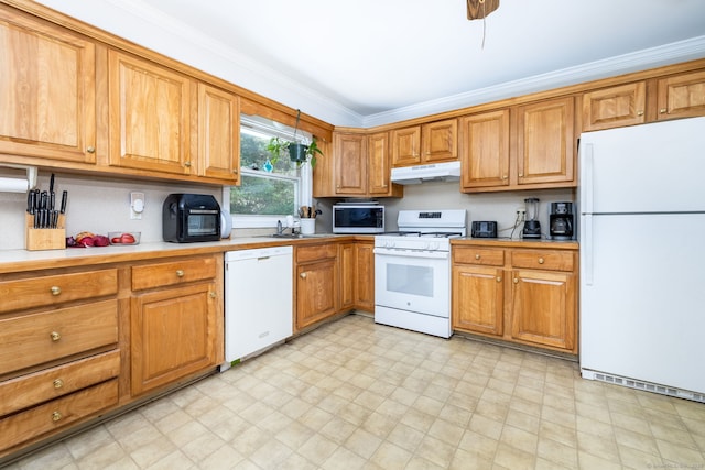 kitchen with a sink, white appliances, light floors, under cabinet range hood, and ornamental molding
