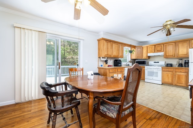 dining room with ceiling fan, ornamental molding, and light wood-type flooring