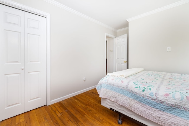 bedroom with baseboards, ornamental molding, and wood finished floors
