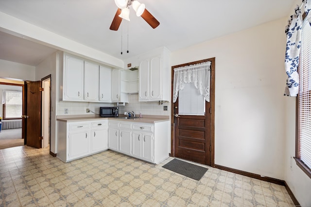 19 Terhune Ave, Branford, CT 06405 - kitchen with light floors, ceiling fan, backsplash, light countertops, and black microwave