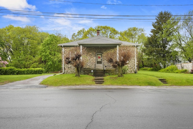 298 Wall St, Waterbury, CT 06704 - view of front facade featuring stone siding, a front yard, and a chimney