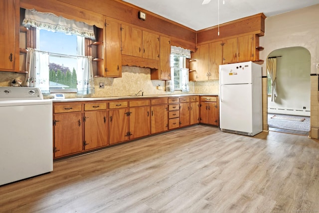 298 Wall St, Waterbury, CT 06704 - kitchen featuring freestanding refrigerator, washer / dryer, a baseboard heating unit, light wood-style flooring, and tasteful backsplash