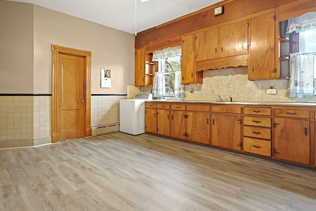 298 Wall St, Waterbury, CT 06704 - kitchen with washer / clothes dryer, a baseboard radiator, light wood-type flooring, brown cabinets, and tile walls