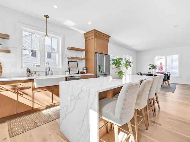 13 Dunbar Rd, Milford, CT 06460 - kitchen with open shelves, a sink, light wood-style floors, high end refrigerator, and tasteful backsplash