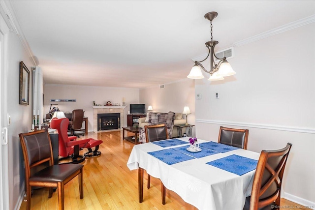 28D Harbour Vlg, Branford, CT 06405 - dining space with ornamental molding, light wood-style floors, and a fireplace