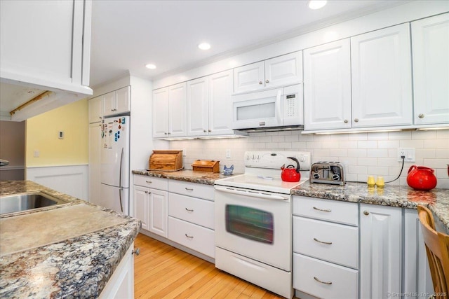 28D Harbour Vlg, Branford, CT 06405 - kitchen with white appliances, white cabinets, light wood finished floors, a sink, and tasteful backsplash