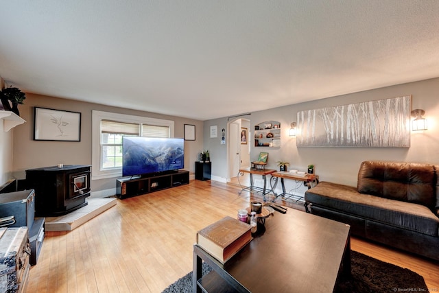 140 College Ave, Torrington, CT 06790 - living area with a wood stove, light wood-type flooring, arched walkways, and baseboards