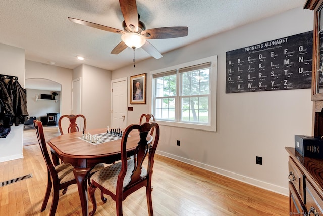 140 College Ave, Torrington, CT 06790 - dining room featuring ceiling fan, baseboards, arched walkways, light wood-style floors, and a textured ceiling