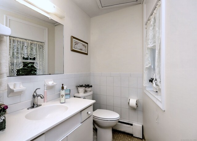 24 Wall St, Shelton, CT 06484 - bathroom with a baseboard heating unit, toilet, vanity, tile walls, and tile patterned flooring