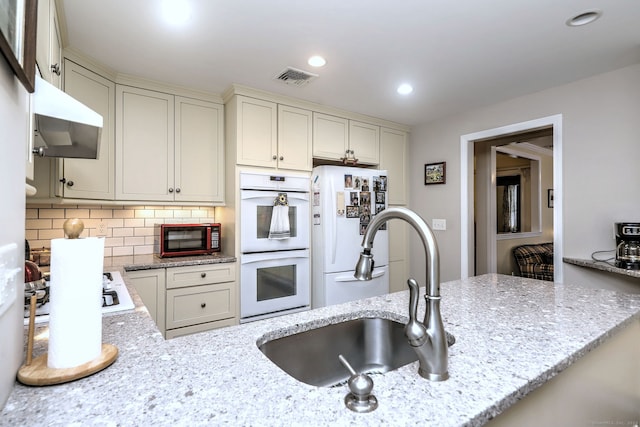 24 Wall St, Shelton, CT 06484 - kitchen featuring white appliances, a sink, decorative backsplash, recessed lighting, and light stone countertops