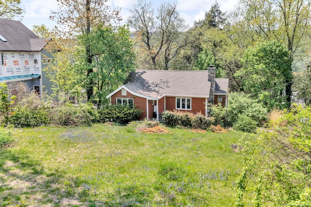 view of front of property featuring a chimney and a front lawn