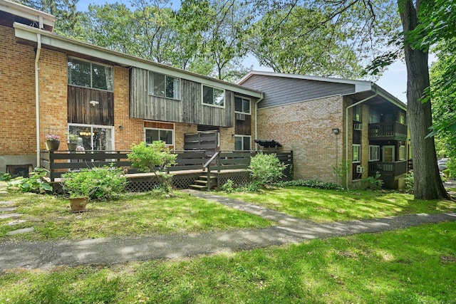 333 Vincellette St Unit 25, Bridgeport, CT 06606 - view of front facade with brick siding, a front lawn, and a wooden deck