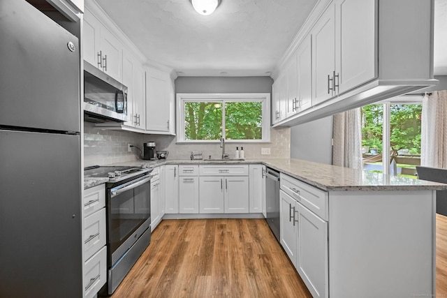 333 Vincellette St Unit 25, Bridgeport, CT 06606 - kitchen featuring appliances with stainless steel finishes, a sink, a peninsula, white cabinetry, and backsplash