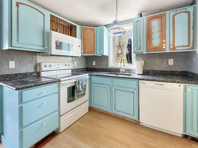 kitchen featuring a sink, blue cabinetry, white appliances, and a textured ceiling