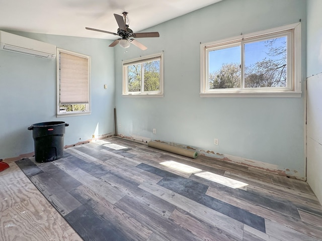 unfurnished bedroom featuring ceiling fan, wood finished floors, a wood stove, and a wall mounted air conditioner